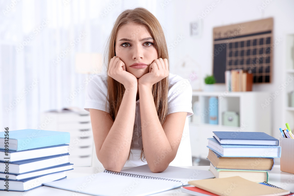 Female student preparing for exam at table indoors Female student preparing for exam at table indoors