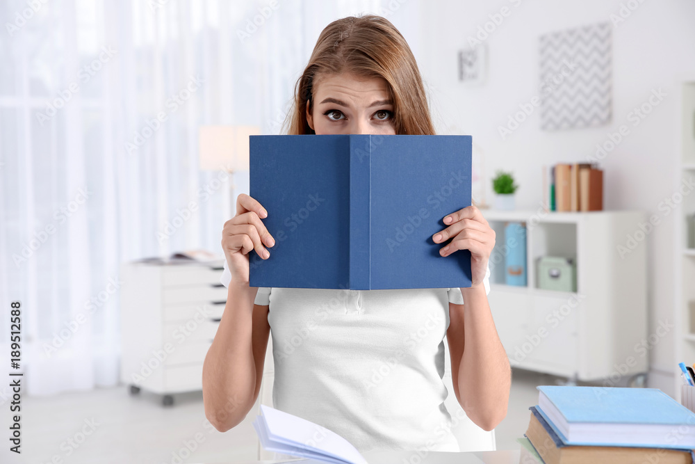Female student preparing for exam at table indoors Female student preparing for exam at table indoors