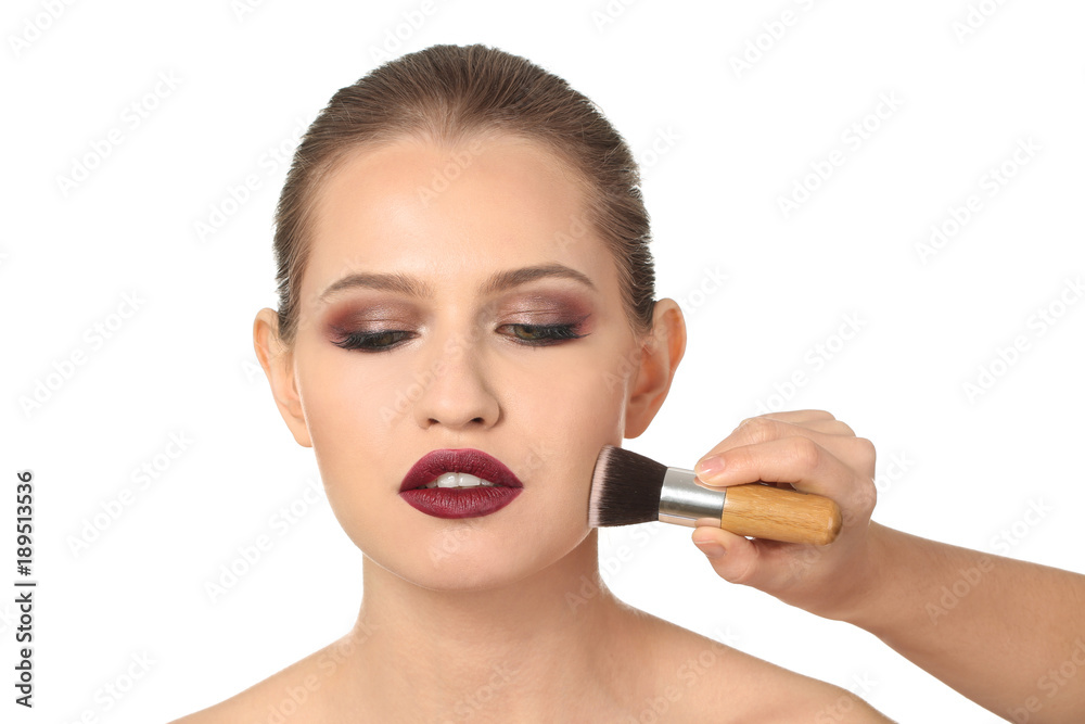 Professional visage artist applying makeup on woman's face on white background Professional visage artist applying makeup on woman's face on white background