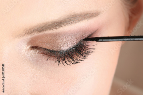 Woman applying makeup, closeup. Professional visage artist work