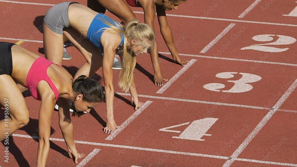 Three female athletes simultaneously start running marathon, rivalry, slow-mo