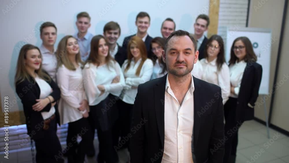 Business power men leader and his staff. 4 k Portrait of a businessman boss and his subordinates who is standing in front of the rest of his diverse business team. They all look into the camera. Business power men leader and his staff. 4 k Portrait of a businessman boss and his subordinates who is standing in front of the rest of his diverse business team. They all look into the camera.