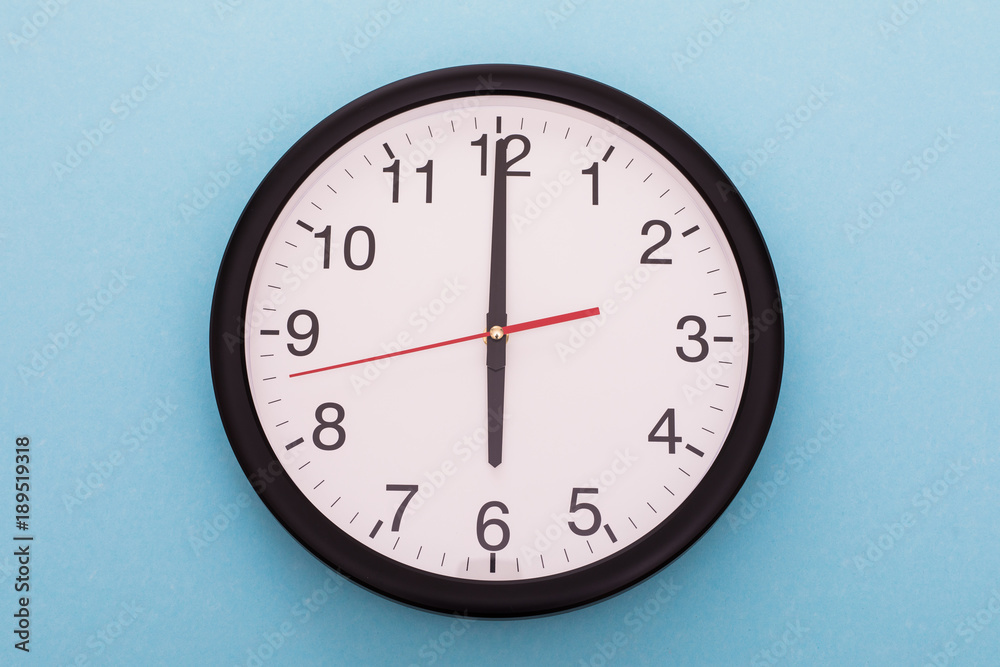 Big wall clock isolated on blue background. Six o'clock. Big wall clock isolated on blue background. Six o'clock.