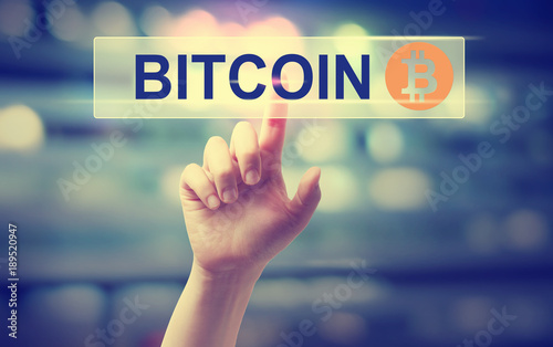 Bitcoin with hand pressing a button on blurred abstract background