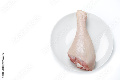 Turkey drumstick with skin in big plate isolated on white background