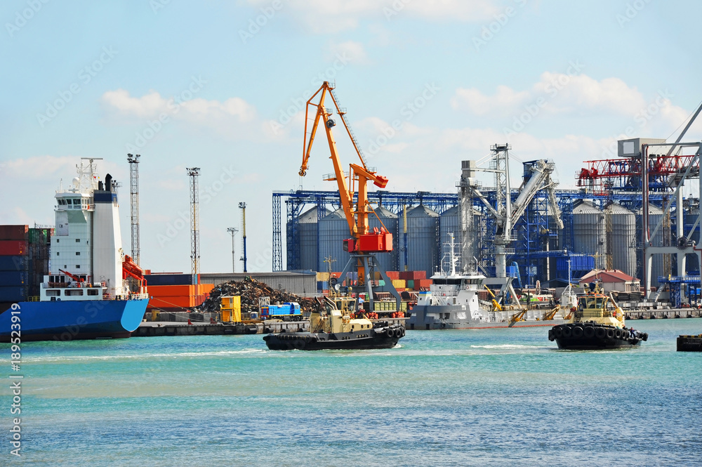 Naklejka premium Tugboat assisting container cargo ship