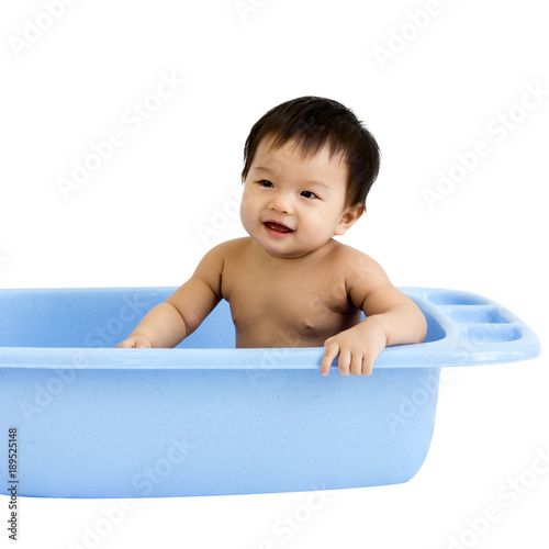 Portrait of adorable baby sitting in the basin for shower, isolaed in white background