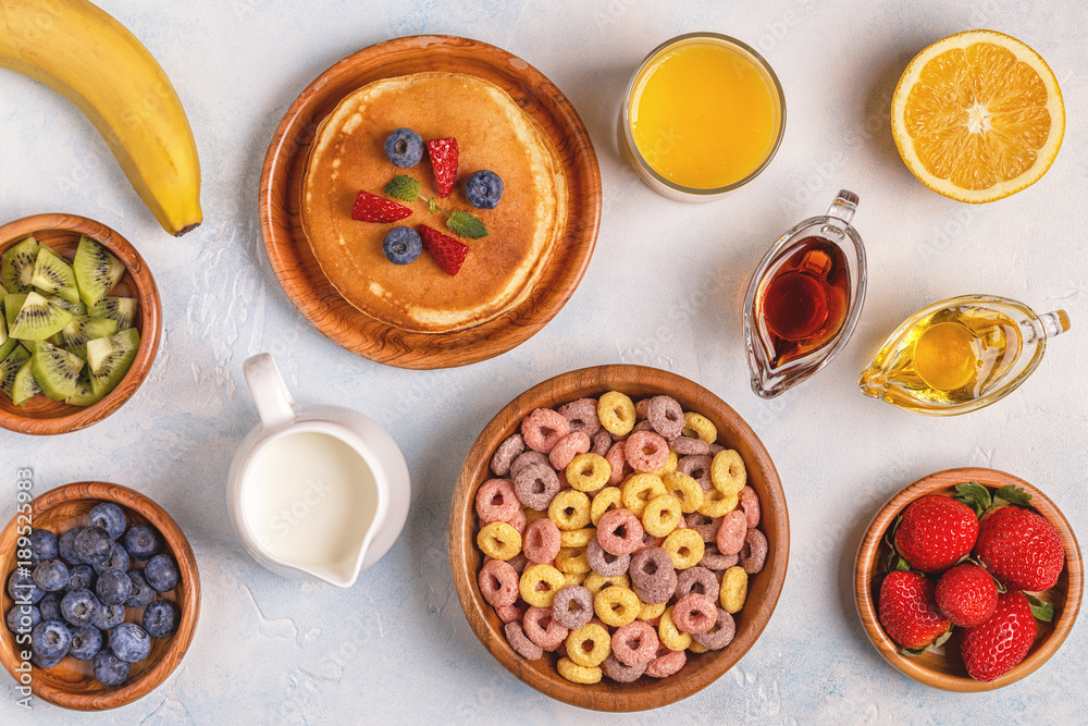 Breakfast with colorful cereal rings, pancakes, fruit, milk, juice. Breakfast with colorful cereal rings, pancakes, fruit, milk, juice.