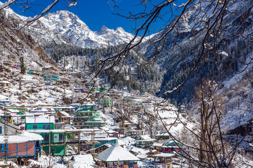 Tosh village in Himachal pradesh, India entirely covered in snow after a massive snow fall in February cold winter. Serene village life in tranquil place. Complete Landscape view photo