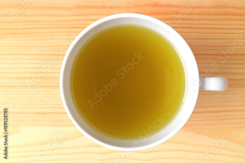 Top View of a Cup of Hot Japanese Green Tea Served on Natural Color Wooden Table 