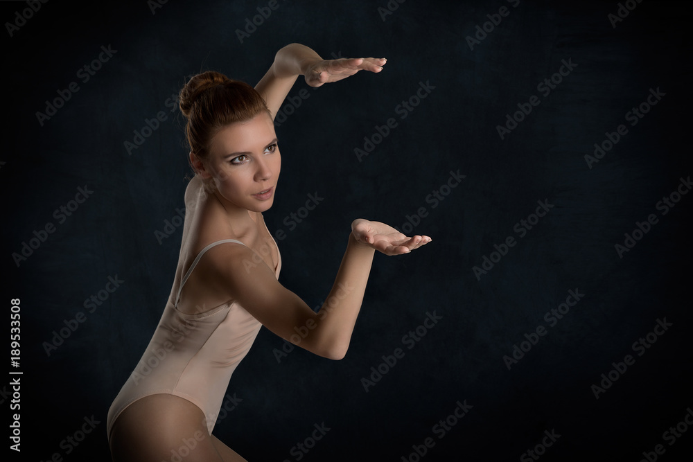 the ballerina  dances on a dark background