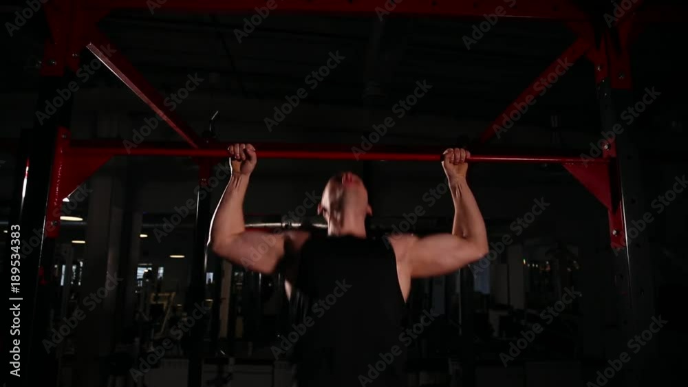 Stedikam movement of the camera, a man in black sportswear is pulling on the bar, then goes to squats with a barbell with a bar. circular training. Stedikam movement of the camera, a man in black sportswear is pulling on the bar, then goes to squats with a barbell with a bar. circular training.