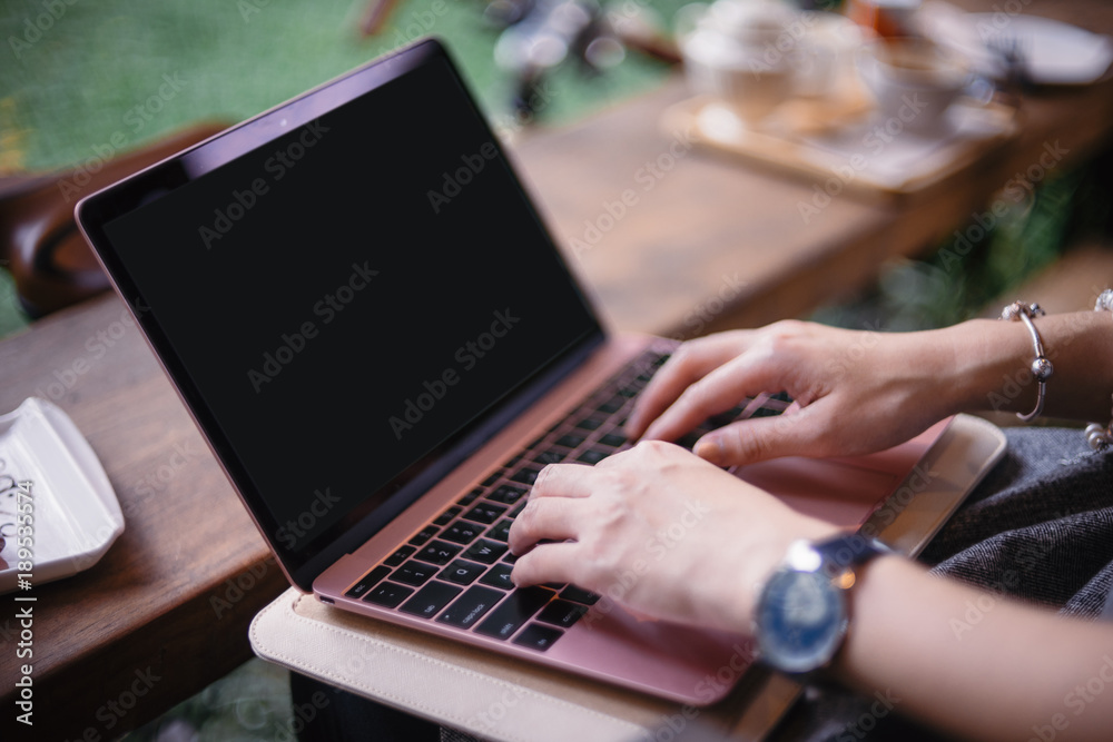 Women hand working on computer notebook in coffee shop