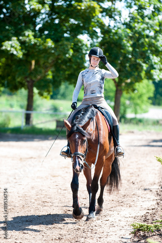 Training is finished. Girl riding a horse at equestrian school