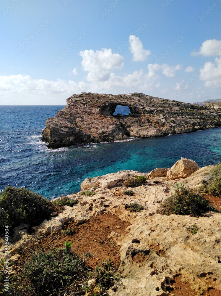 Comino island blue lagoon. Malta blue turquoise sea water beach. Rock and cliff sunny seashore. Travel mediterranean.