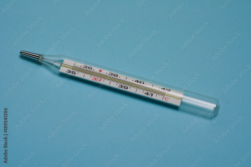 One glass smooth pharmaceutical thermometer with mercury on blue background One glass smooth pharmaceutical thermometer with mercury on blue background