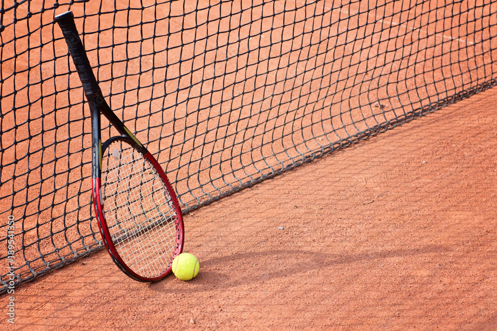 tennis racket and balls on the clay court
