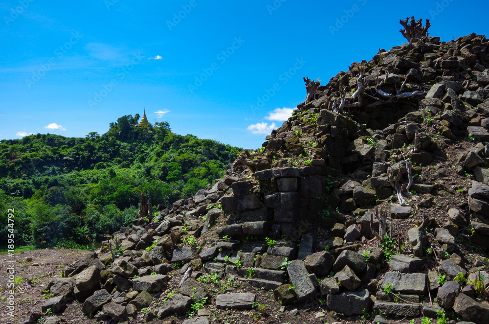 A broken pagoda being reclaimed by nature in Mrauk U, Myanmar
