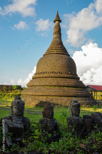 An ancient pagoda of the Mrauk U  Myanmar heritage in the back of small  damaged Buddha statues