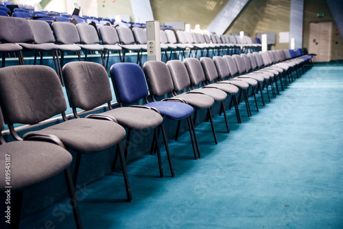 Many comfortable chairs in empty conference hall. Selective focus. Different from others. © gorynvd