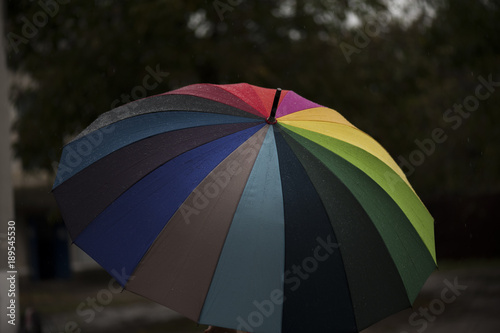 Close-up  umbrella in rainbow colors in rainy autumn day  blur focus
