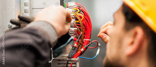 Electrician engineer tests electrical installations on relay protection system photo