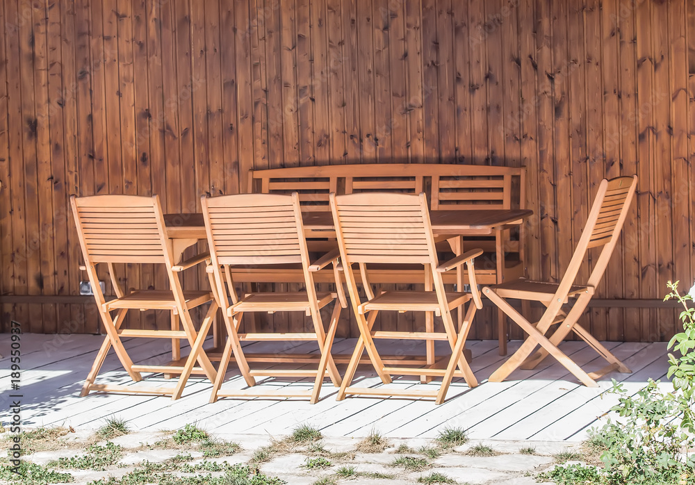 Wooden table and chairs under a canopy