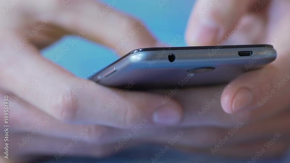 Hands scrolling mobile app choosing appropriate tariff plan for calls in roaming Hands scrolling mobile app choosing appropriate tariff plan for calls in roaming