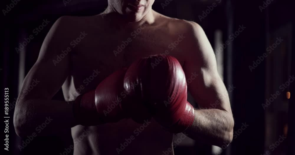Vidéo Stock Boxer puts on boxing gloves. Male fighter putting his ...
