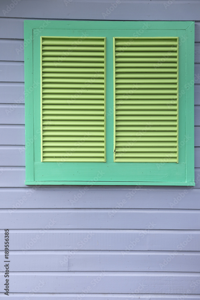 Green Louvered Window on Gray Wooden Panel Wall