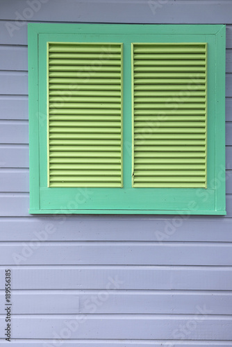 Green Louvered Window on Gray Wooden Panel Wall