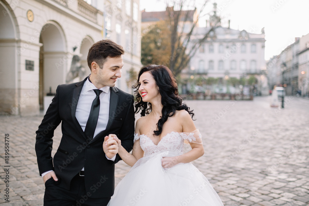 Bride and groom walking through the old town Bride and groom walking through the old town