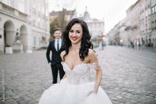 Portrait of a romantic beautiful couple traveler walking in the street in summer in old city. © VAKSMANV