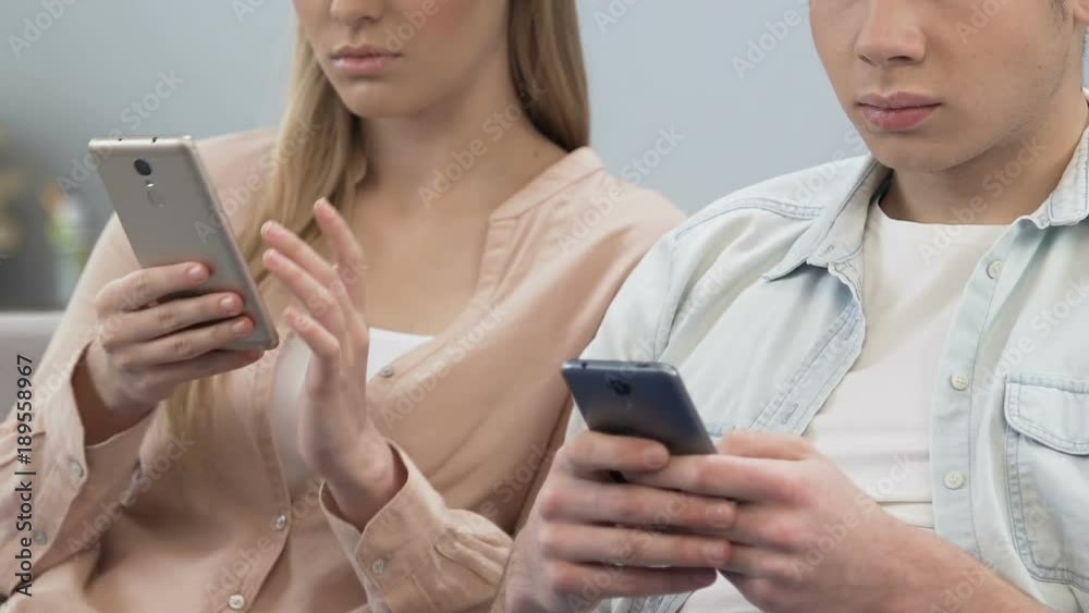 Two students downloading application on cellphone, lack of live communication Two students downloading application on cellphone, lack of live communication