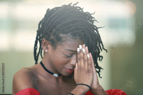 Photography Black female praying with closed eyes
