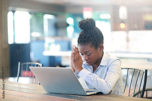 Black female praying while working