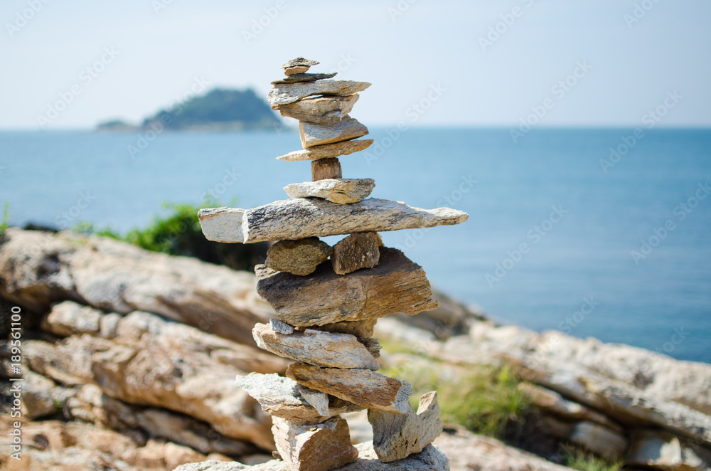 Stones balanced and stacked overlooking the blue ocean Stones balanced and stacked overlooking the blue ocean