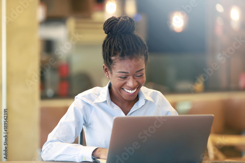 Cheerful African girl at notebook
