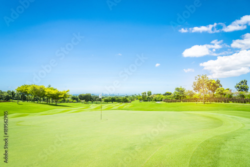 Green golf court with blue could sky background