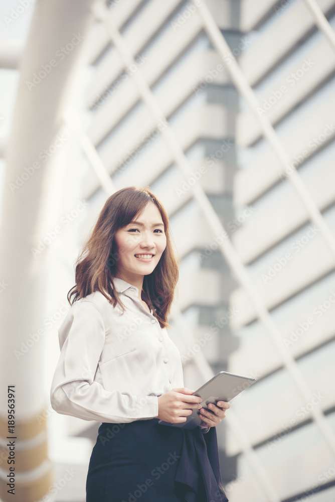 Young beautiful working woman holding smart tablet in the city. Young beautiful working woman holding smart tablet in the city.