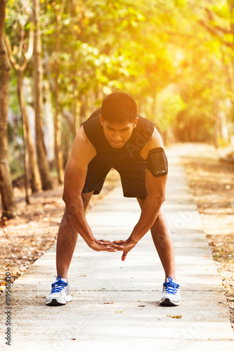 handsome man doing exercises and warm up before run and Physical fitness test ; Healthy lifestyle cardio together at outdoors summer .