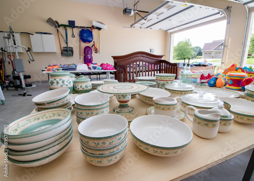 Dishes and children's clothing on display at a typical American garage sale