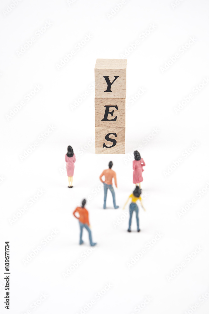 people standing at yes lettering cube on white background people standing at yes lettering cube on white background