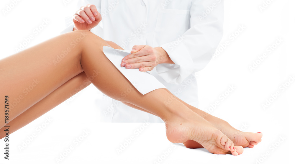 Beauty Spa. Hair removal cosmetology procedure.  Beautician waxing female legs
