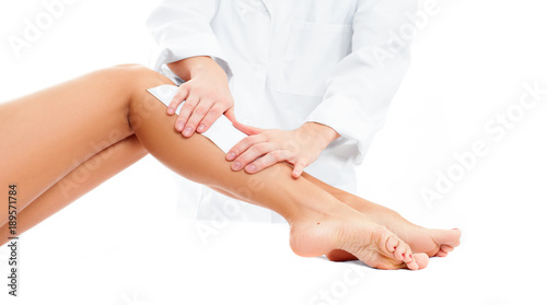 Beauty Spa. Hair removal cosmetology procedure. Beautician waxing female legs