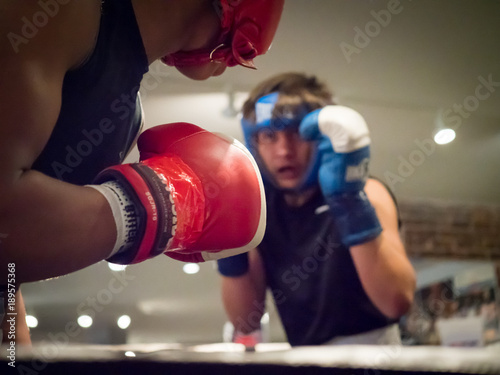 Amateur boxer loading up a punch, rear view