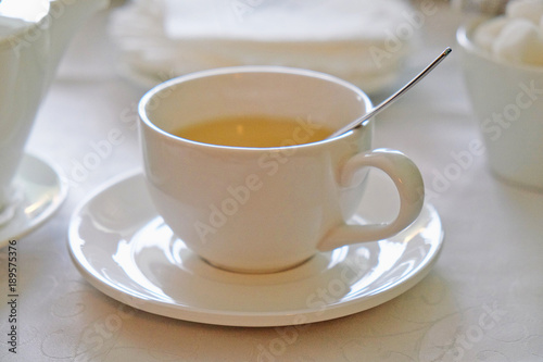 tea in a white mug on the table in a cafe