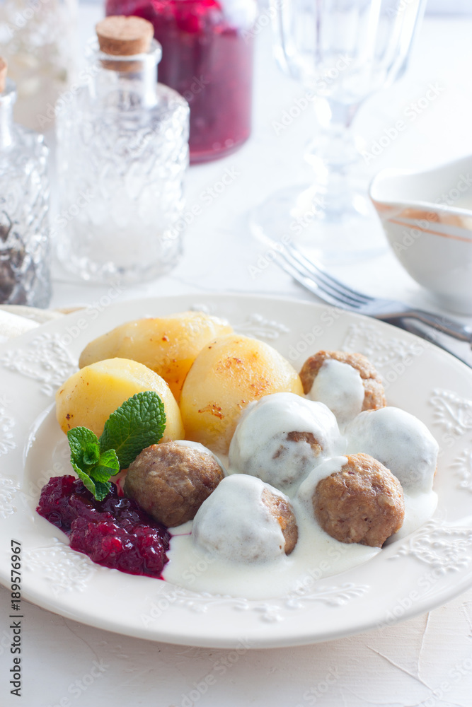 Meatballs with cream sauce and cranberry jam, on a white plate, selective focus Meatballs with cream sauce and cranberry jam, on a white plate, selective focus