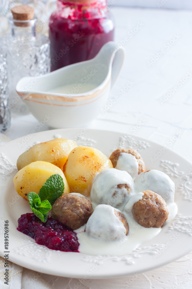 Meatballs with cream sauce and cranberry jam, on a white plate, selective focus Meatballs with cream sauce and cranberry jam, on a white plate, selective focus