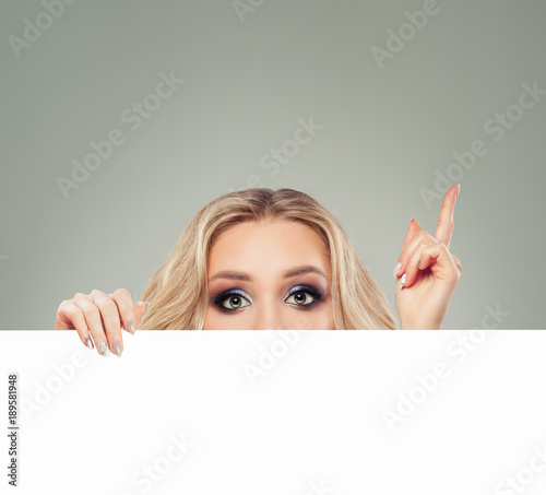 Woman Fashion Model with White Blank Board Paper Banner Background. Girl Pointing Up